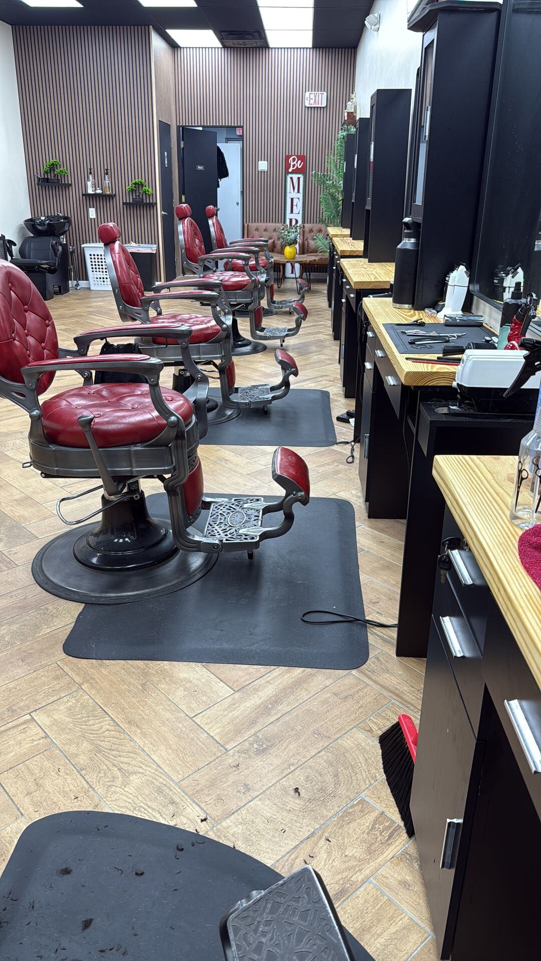 Red tufted vintage barber chairs in a row at The Men's Barbershop